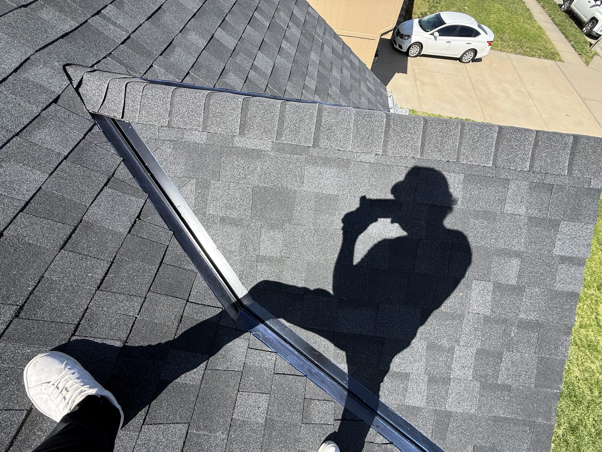 Close view of overlapping shingles along a roof ridge