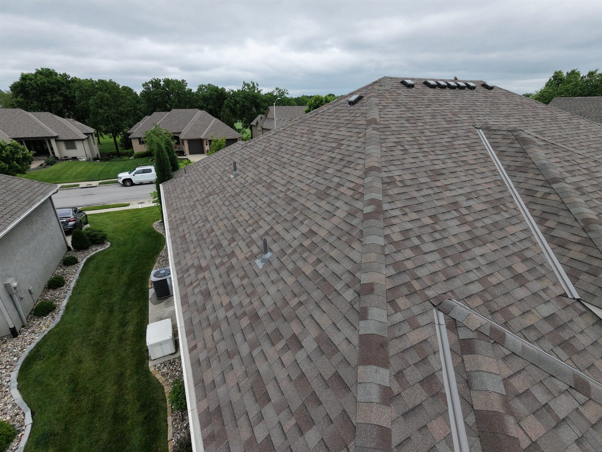 Aerial view of a completed shingle roof with ridges, valleys, and vents
