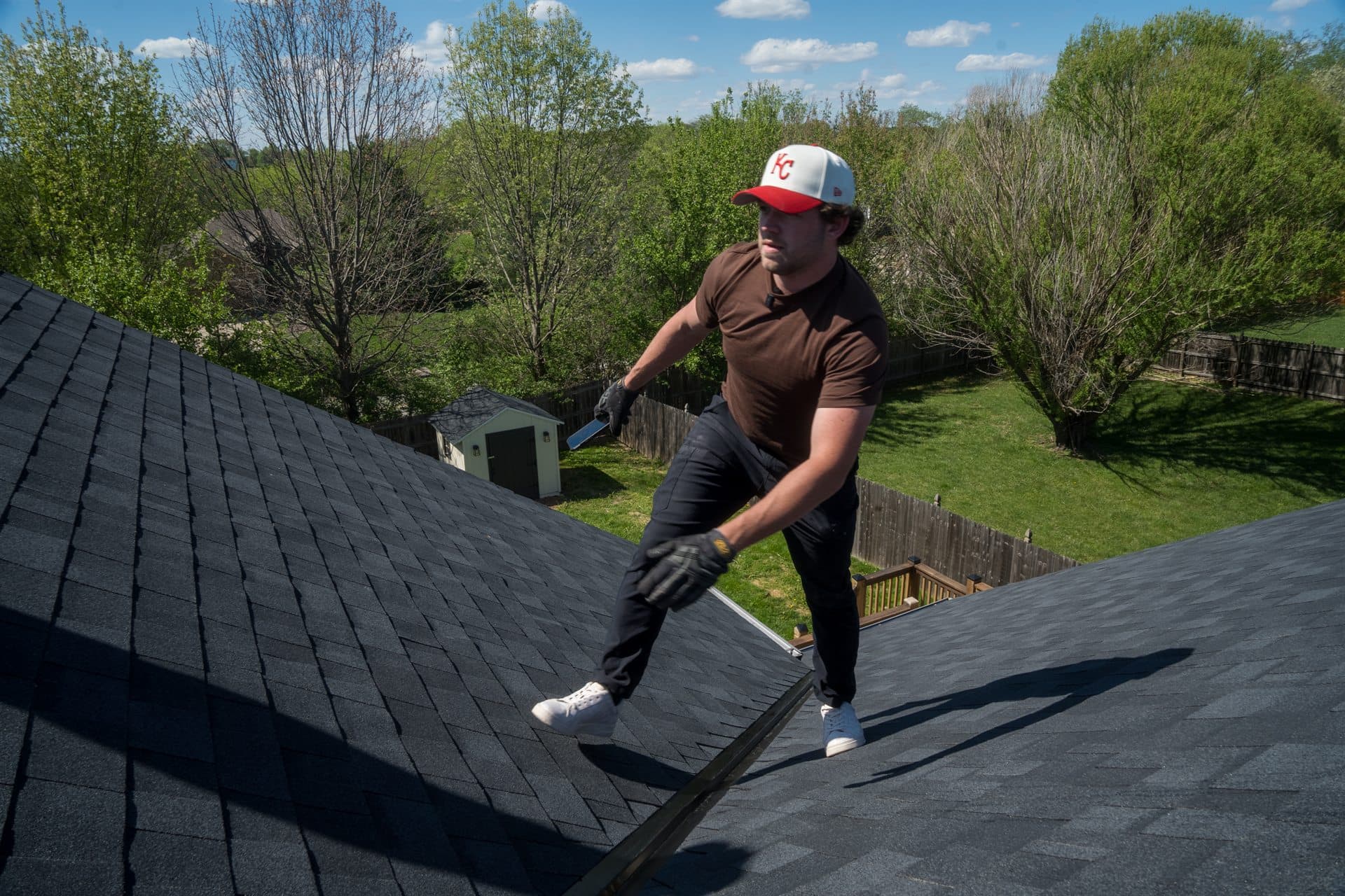 MCO Roofing professional on a finished shingle roof at sunset in Kansas