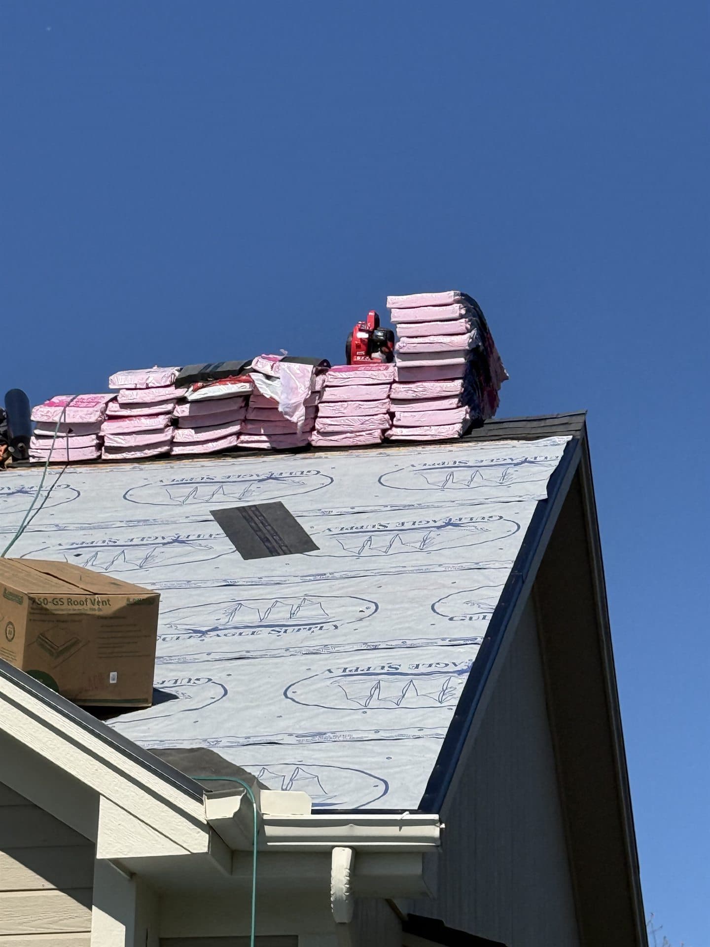 Roof replacement in progress with new synthetic underlayment before shingle installation