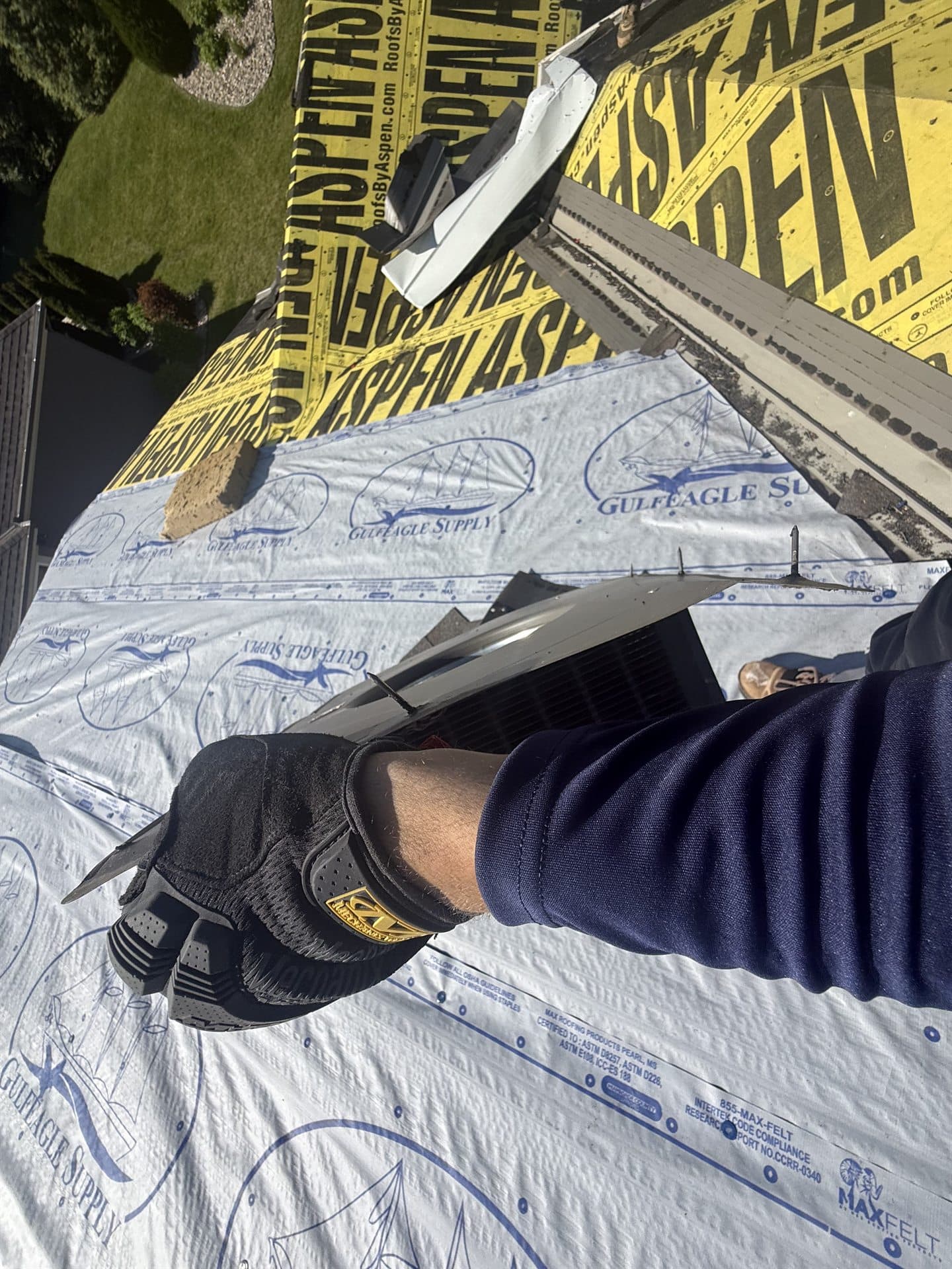Roofing professional installing new asphalt shingles during a roof repair in Kansas