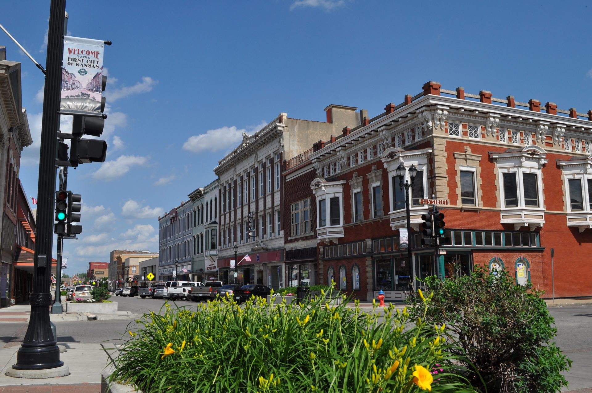 Historic brick storefronts in downtown Leavenworth beneath a Welcome to the First City of Kansas banner
