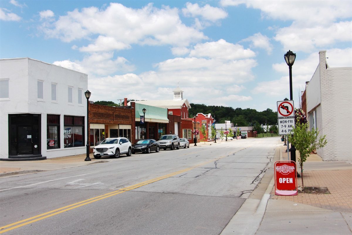 Storefronts and parked cars along a street in historic downtown Merriam