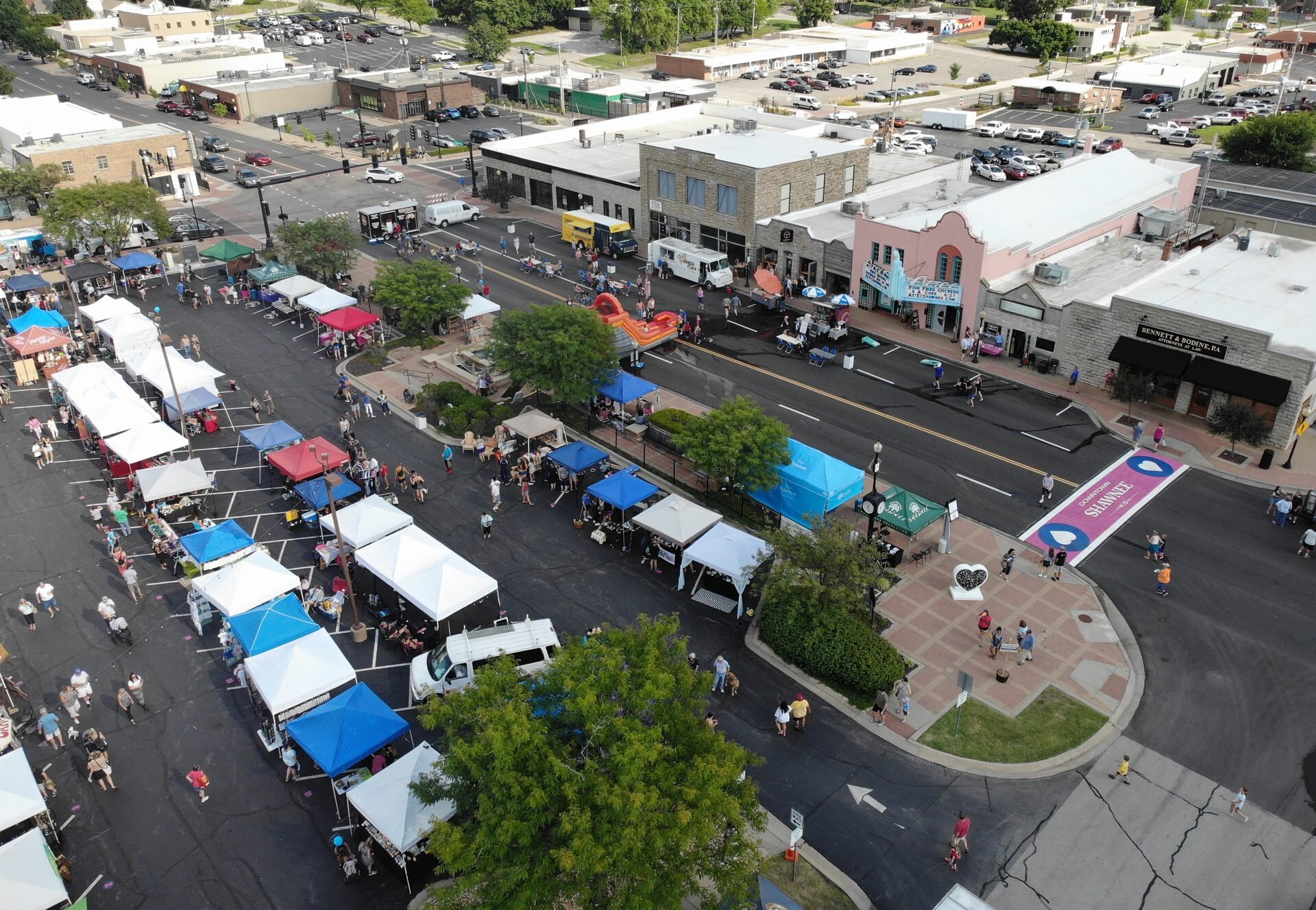Aerial view of a summer street fair in downtown Shawnee, with Shawnee painted on the crosswalk