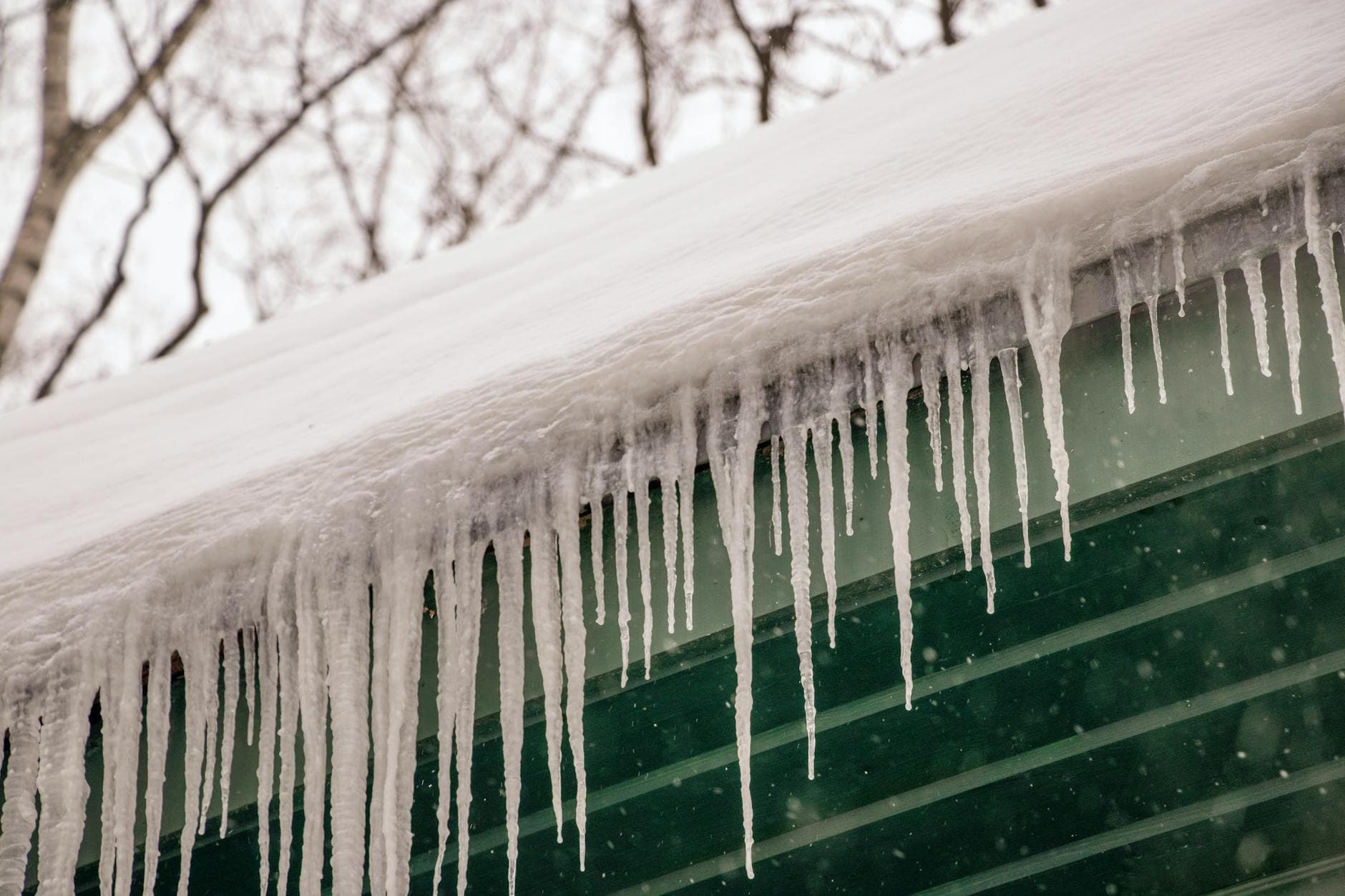 Ice dam formation along the eaves of a Kansas home in winter