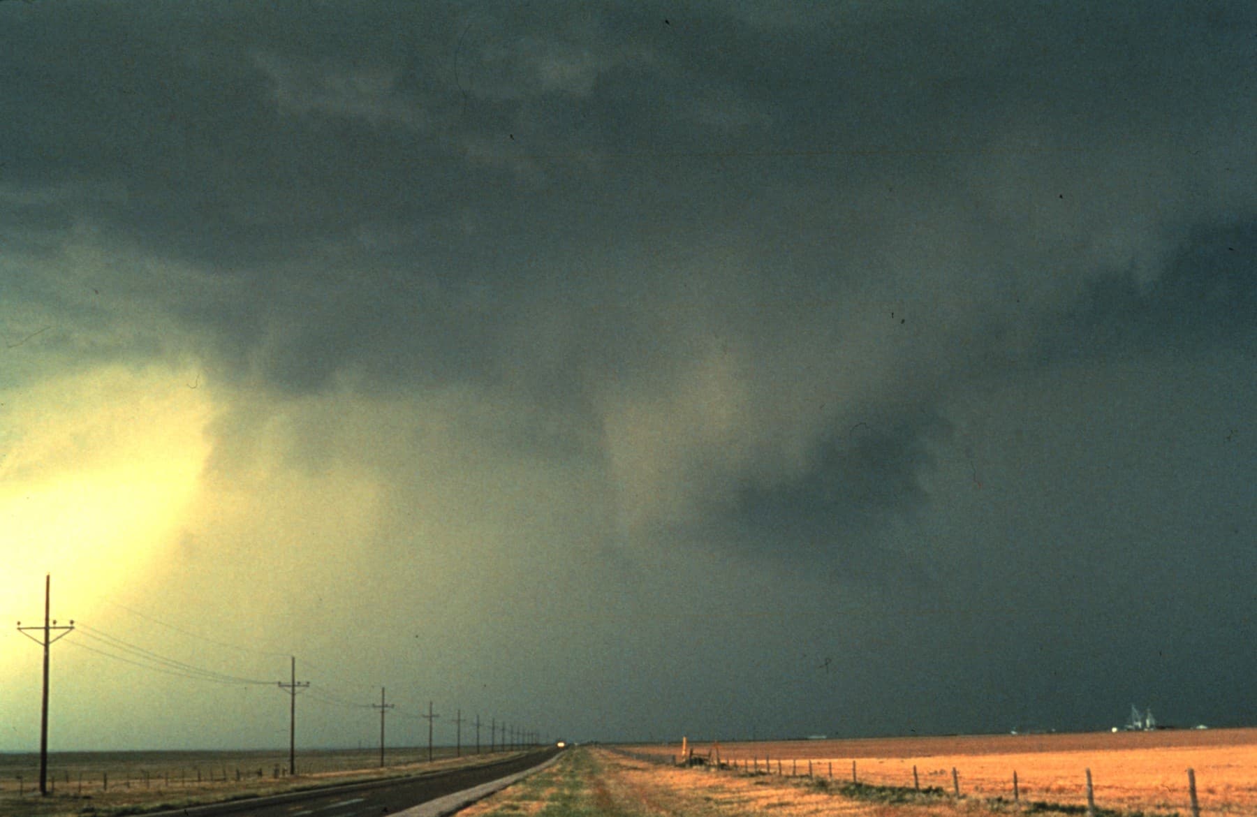 Dark thunderstorm clouds and rain over open land in a NOAA archive photo