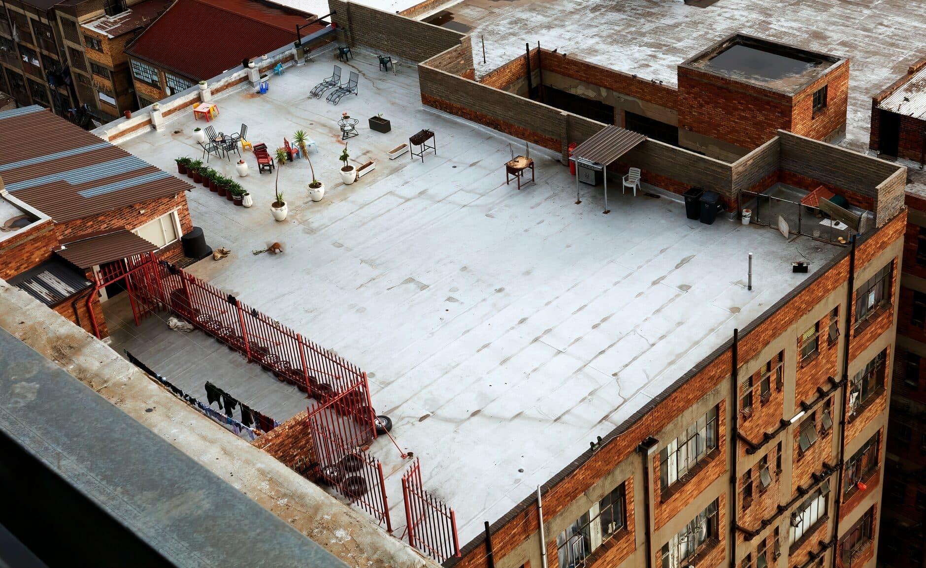 Overhead view of a gray coated flat roof on a brick building
