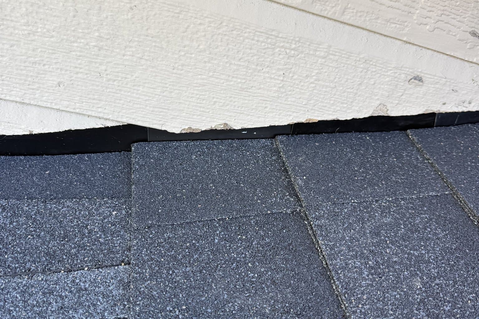 Close-up of freshly installed architectural asphalt shingles and a clean gutter line on a Kansas residential roof after a repair by MCO Roofing