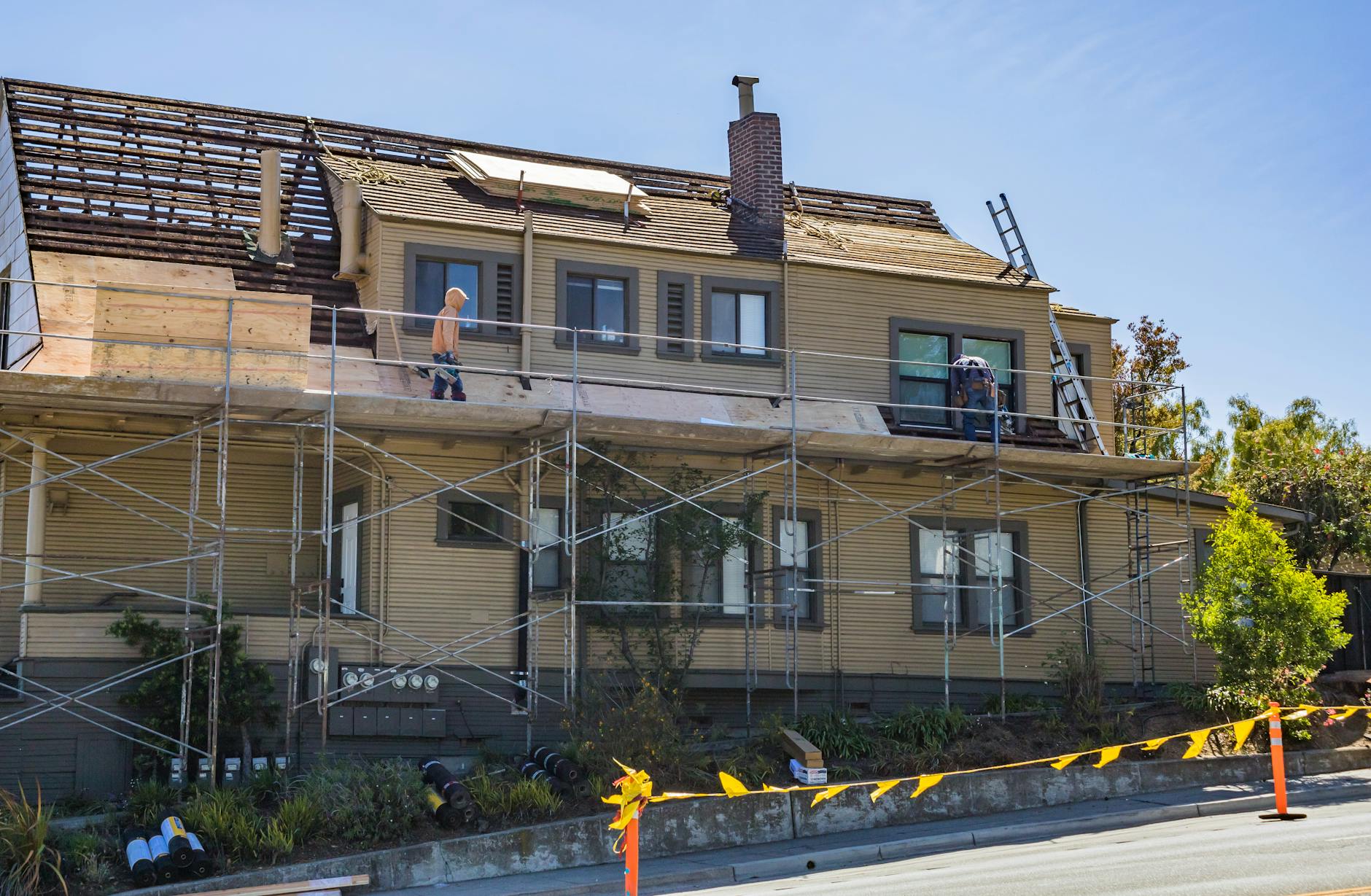 Roofer inspecting shingles on a residential Kansas home